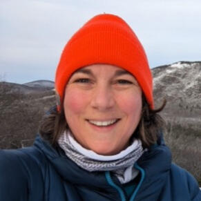 Emma Wendt, Energy Professional & Maine Resident Photo of woman wearing orange hat with snowy natural hills in the background